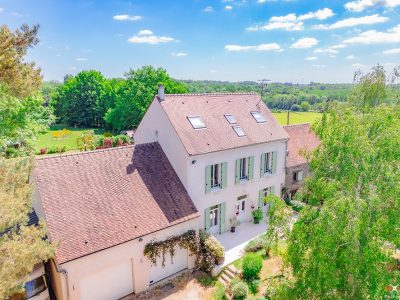 Vue aérienne et au sol d'une propriété de charme, avec sa piscine, son jardin paysager et sa façade en pierre.